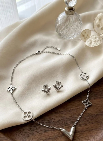 Elegant V Jewelry Set Silver necklace and earrings on cream silk